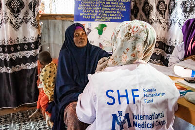 A woman receives a checkup from an International Medical Corps (IMC) health worker at the Sirmaqabe IDP settlement in Galkayo, Somalia, July 2023.