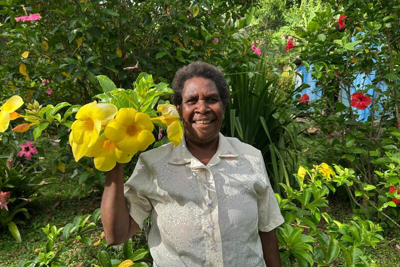 Anna at her home with an allamanda flower.